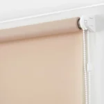 Beige blackout roller blinds installed in a modern dining room.