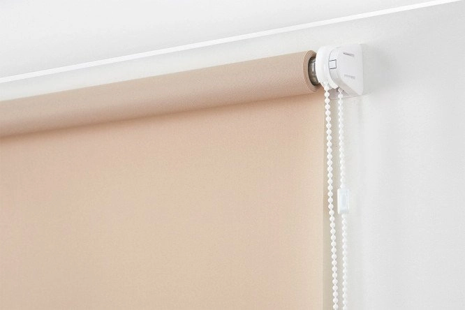 Beige blackout roller blinds installed in a modern dining room.