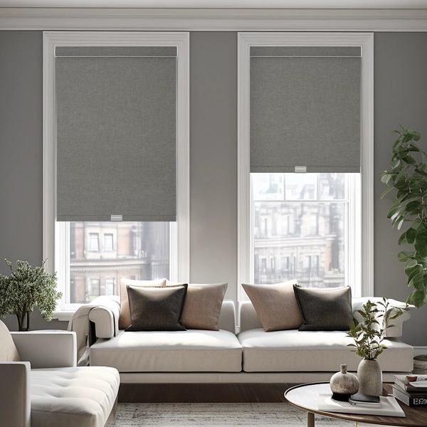 Grey roller shades over a white sofa.