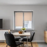 Neutral-toned blackout roller blinds mounted on a double window