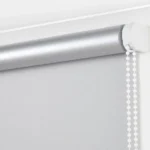 Side view of the silver blackout blind roller and its white beaded chain
