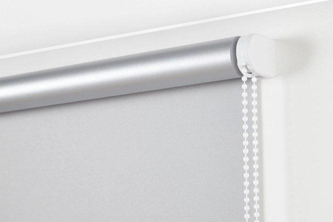 Side view of the silver blackout blind roller and its white beaded chain