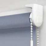 top-fix mounting bracket holding a denim blue roller blind